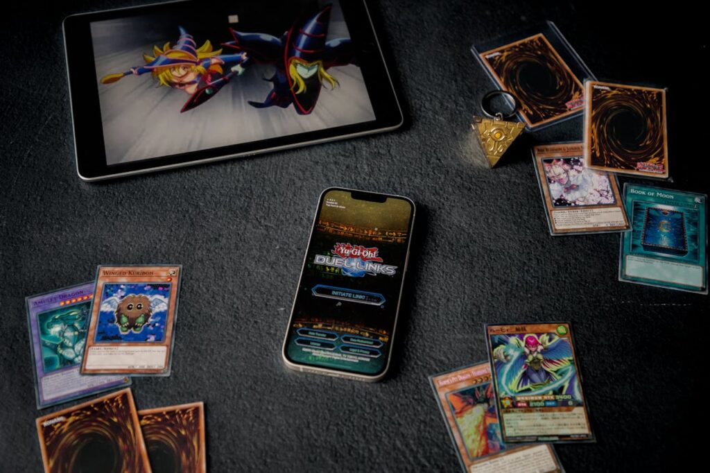 Yu-Gi-Oh cards displayed with tablet and phone, featuring Duel Links game.
